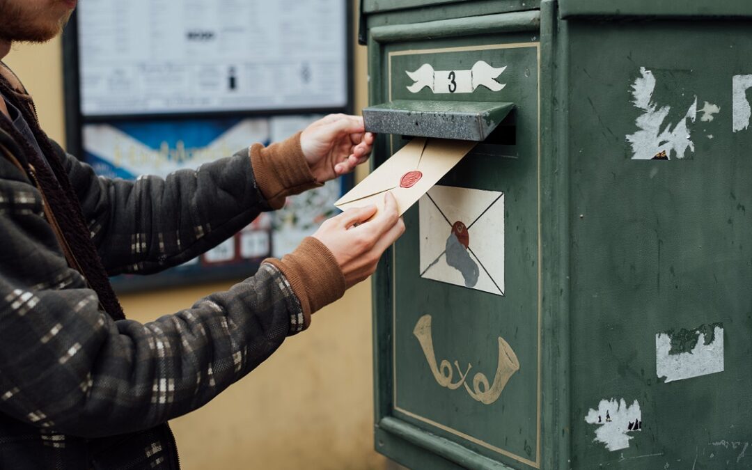 Mailing letter with wax seal to old postbox on street