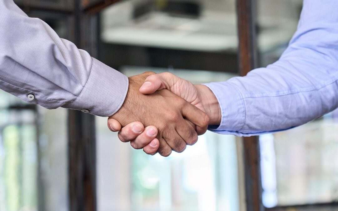 Two businessmen shake hands with business handshake at office meeting. Manager and client or partners trust and acquisition partnership, trade agreement, help and cooperation, leadership concept.