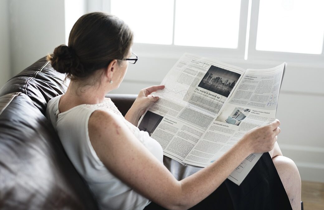 Businesswoman reading a newspaper on a couch