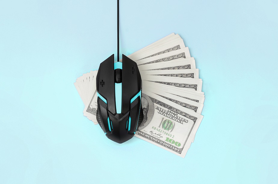Computer mouse on many dollar bills. Pay per click and autoclicker concept. Earnings on the Internet. Flat lay top view on pastel blue background